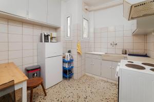 Charming 1Bd apartment in Athens في أثينا: مطبخ مع ثلاجة بيضاء ومغسلة