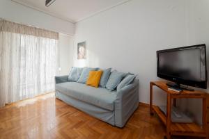 sala de estar con sofá y TV de pantalla plana en Charming 1Bd apartment in Athens en Atenas