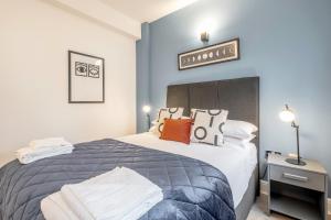 een slaapkamer met een groot bed met blauwe muren bij Kula London - Tower Bridge in Londen