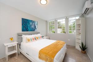 a white bedroom with a large bed and windows at Waterfront Luxury Home with Dock in San Juan in Pinones +24 photos