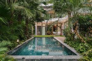 una piscina en un jardín con palmeras en Rosee Villa - Eco Green Villa in Flamigo Dai Lai Resort, en Vĩnh Phúc