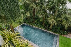 una piscina vacía en un jardín con palmeras en Rosee Villa - Eco Green Villa in Flamigo Dai Lai Resort, en Vĩnh Phúc