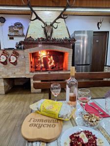 einen Tisch mit einer Flasche Wein und einen Kamin in der Unterkunft Perla in Dospat