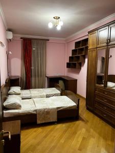 a bedroom with two beds and a dresser at Home in Yerevan