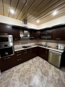 a kitchen with wooden cabinets and stainless steel appliances at Home in Yerevan