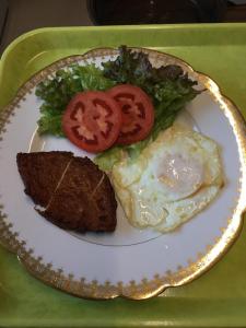 a plate of food with eggs and bread and tomatoes at Accommodation Service B&B in Miyazaki