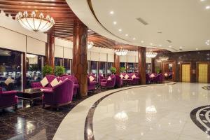 a hotel lobby with purple chairs and a bar at Cristal Erbil Hotel in Erbil