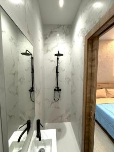 La salle de bains est pourvue d'une baignoire, d'un lavabo et d'un miroir. dans l'établissement Diamonds Luxury Apartments, à Marsalforn