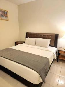 a bedroom with a large bed with a wooden headboard at White Suite At Times Square in Kuala Lumpur