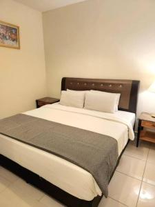 um quarto com uma cama grande e uma cabeceira em madeira em White Suite At Berjaya Times Square (Bukit Bingtang) em Kuala Lumpur