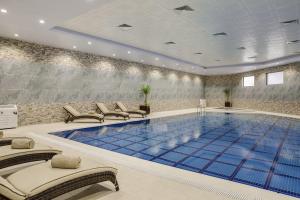 a swimming pool with chairs and a large blue pool at Cristal Erbil Hotel in Erbil