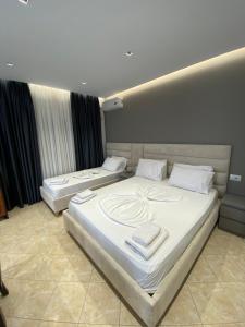 Dos camas en una habitación de hotel con toallas. en Hotel Erioni, en Sarandë