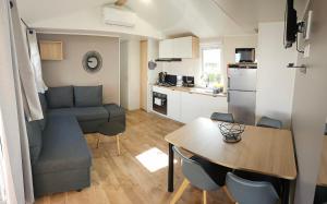 ein kleines Wohnzimmer mit einem Tisch und einer Küche in der Unterkunft Les rives de condrieu in Condrieu