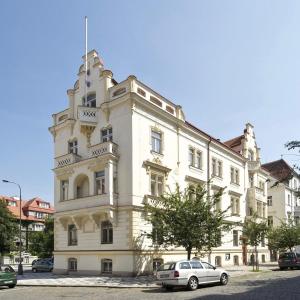 Biały budynek z samochodem zaparkowanym przed nim w obiekcie Muchovka Apartment w Pradze