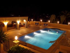 a swimming pool in a backyard at night at Villa Senomar in Benissa