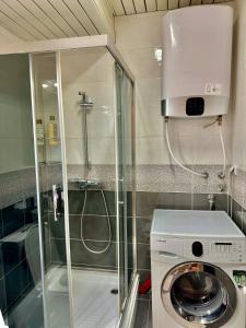 eine Waschmaschine im Bad mit Dusche in der Unterkunft Modern & Cozy in Skopje