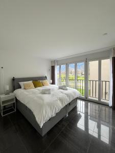 um quarto com uma cama grande e uma janela grande em Center Park em Interlaken