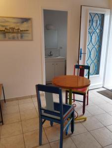 a kitchen with a table and two chairs and a table at Eure et Loir- Le Catalpa in Goussainville