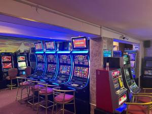 a row of slot machines in a room with stools at Lucky Star Hotel in Chiclayo