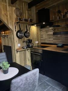 a kitchen with wooden walls and a table and a stove at gezellige cottage in zeeland in Sint Annaland +31 photos