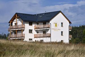 een groot wit gebouw met een zwart dak bij Apartmány Smrkový vrch in Vaclavov u Bruntalu