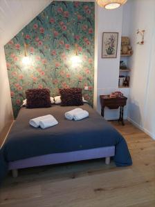1 dormitorio con 1 cama con pared de flores en Le clos du prieuré, en Montjean-sur-Loire