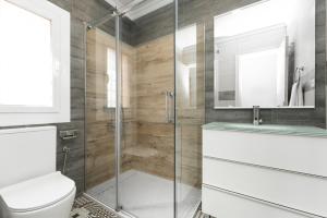 a bathroom with a toilet and a glass shower at La Sagrera House in Barcelona