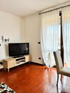 een woonkamer met een flatscreen-tv en gordijnen bij La casa di Jacopo a Fiumicino in Maccarese