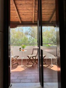Une porte ouverte s'ouvre sur une terrasse avec une table et des chaises. dans l'établissement La casa di Jacopo a Fiumicino, à Maccarese
