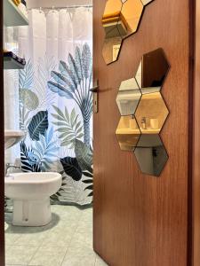 a bathroom with a toilet and a door with a sink at La casa di Jacopo a Fiumicino in Maccarese +16 photos