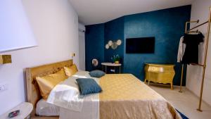 a bedroom with a bed and a blue wall at Ars de mar in Martinsicuro