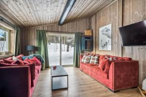 a living room with two red couches and a tv at Stor familiehytte på Bjorli in Bjorli