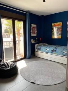 1 dormitorio con cama y pared azul en Precioso piso con piscina, en Salobreña