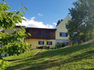 ein Haus an der Seite eines grasbewachsenen Hügels in der Unterkunft FerienAppartments Landhaus FühlDichWohl in Fehring