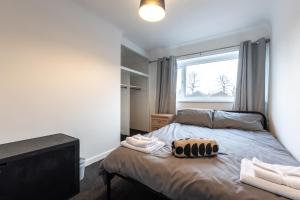 Dormitorio pequeño con cama y ventana en NEW - Central Modern Flat in Southampton, Sleeps 5, Free Off-Road Parking, Close to Hospital, Cruise terminal and Centre, Great for contractors, friends & families, en Southampton