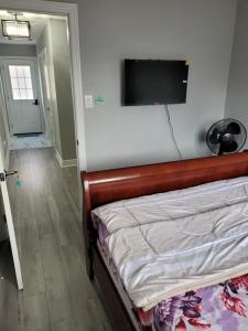a bedroom with a bed with a flat screen tv on the wall at Individual home in Brampton