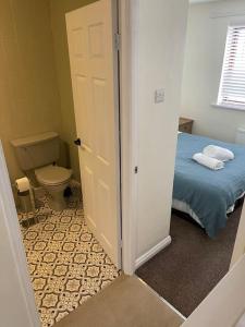 a bathroom with a bed and a toilet in a room at Rotherham,Meadowhall,Magna,Utilita Arena,with WIFi and Driveway in Kimberworth