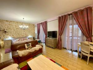 a bedroom with a couch and a bed and a television at Domaine Ô Clair de Lune - Chambres d'Hôtes et Gîtes à Sarlat - Accès Cité Médiévale 5 minutes à pied - Parking - SPA & Massages en option - Piscine de saison in Sarlat-la-Canéda +69 photos