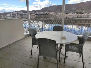 una mesa y sillas en un balcón con vistas al agua en Katerina studios rooms-Biker friendly hotel, en Kastoria