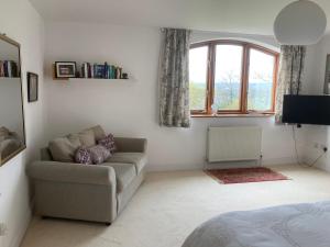 a living room with a couch and a window at Yellowstone, The Garden Apartment in Radstock