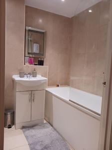 a bathroom with a tub and a sink and a bath tub at Stanmore in Stanmore