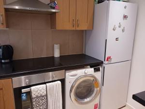 uma cozinha com um frigorífico e uma máquina de lavar roupa em Stanmore em Stanmore