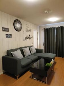 ein Wohnzimmer mit einem grünen Sofa und einem Tisch in der Unterkunft Baan Kidtang in Ban Talat Rangsit