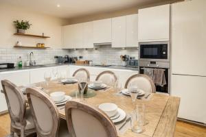 a kitchen with a wooden table and chairs in a kitchen at Pass the Keys Stylish Central St Albans Flat with Free Parking in Saint Albans