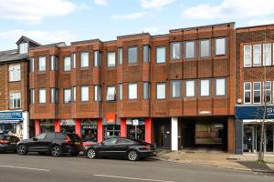 a red brick building with cars parked in front of it at Pass the Keys Stylish Central St Albans Flat with Free Parking in St. Albans