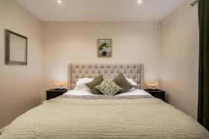 een slaapkamer met een groot bed met 2 lampen bij Pass the Keys Stylish Central St Albans Flat with Free Parking in Saint Albans