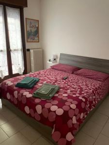 1 dormitorio con 1 cama roja y 2 platos verdes en Casa Pompei, en Vigevano