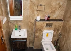 a bathroom with a white toilet and a sink at Chic Apartment#Couple Goal#High Rise#Balcony#condo in Noida