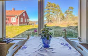 a table with a vase with flowers on it in front of a window at Gorgeous Home In Strmstad With House Sea View in Strömstad