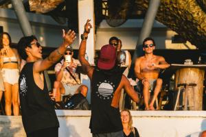 a group of people watching a man on a stage at Outpost Beach Hostel in El Nido